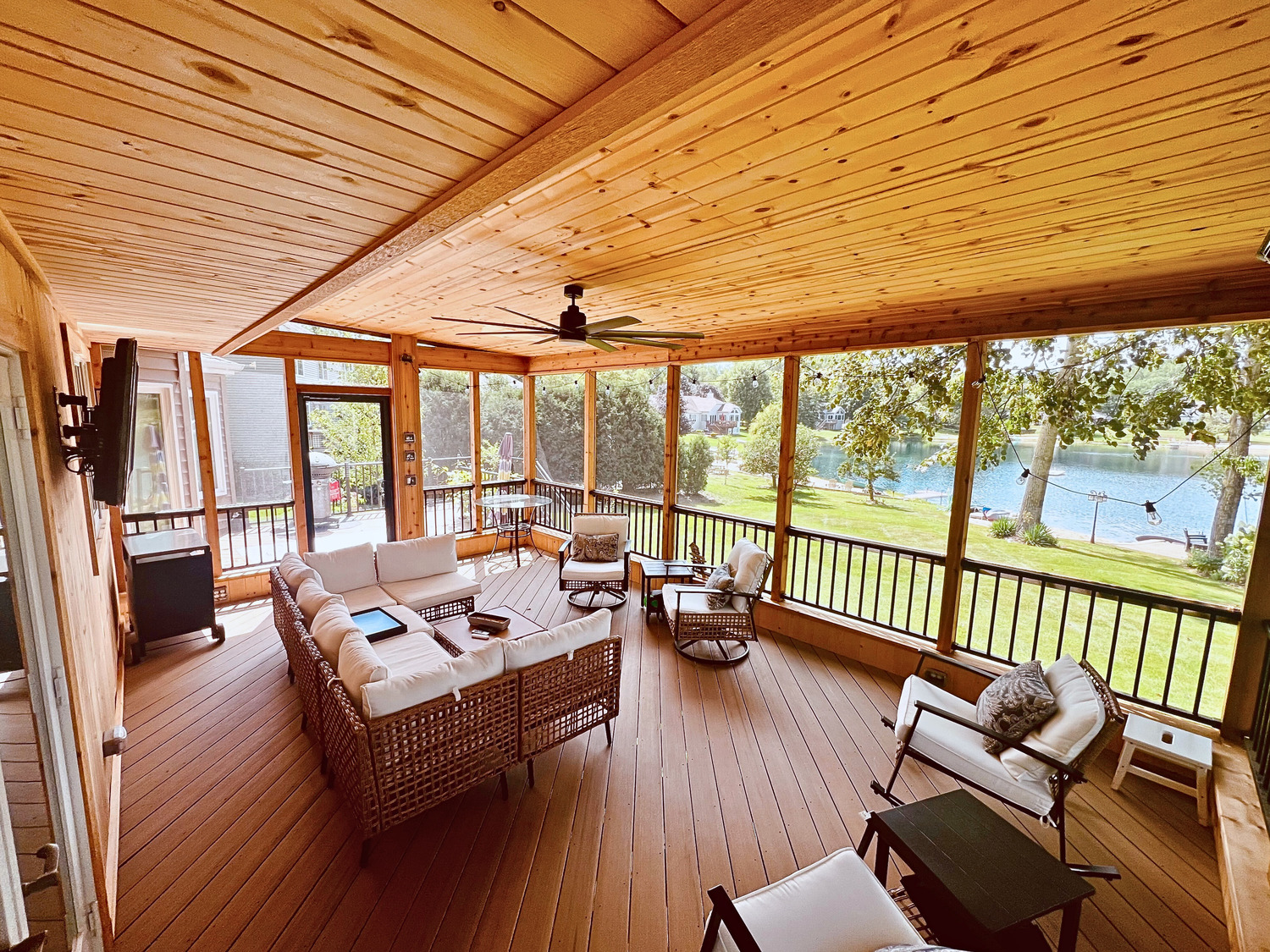 porch on the back of a home with a ceiling fan and patio furniture